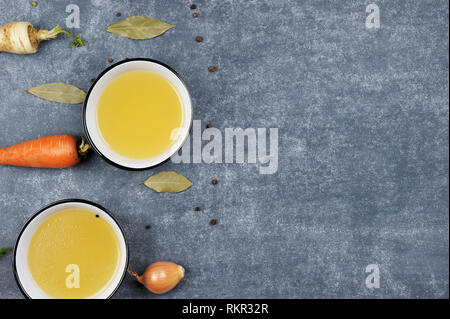 Brodo con un ingrediente in due ciotole.chiara brodo è realizzato facendo sobbollire di carne o di ossa e le verdure. Preparato con pepe nero, carota, cipolla, Foto Stock