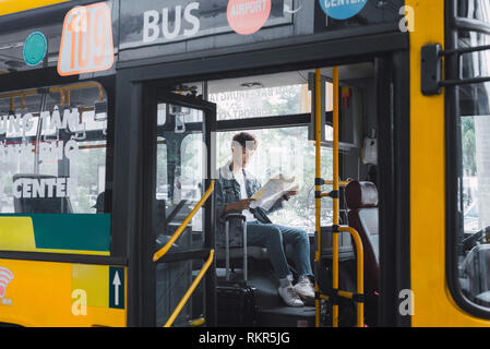 La città di HO CHI MINH, VIETNAM - 22 luglio, 2017: Trasporto. Persone in bus. Egli la lettura di libro in trasporto. Foto Stock