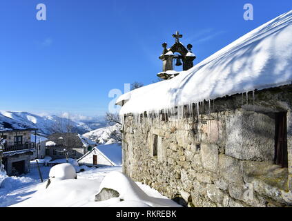 Piornedo, Ancares, provincia di Lugo, Galizia, Spagna. Vista da San Lorenzo hermitage con neve, ghiaccio e ghiaccioli. Villaggio nevoso e montagne. Foto Stock