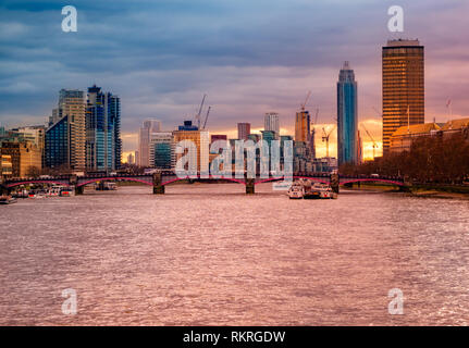 Bella vista panoramica dei famosi edifici aziendali e il fiume Tamigi illuminato al tramonto, Cityscape di Londra nel Regno Unito Foto Stock