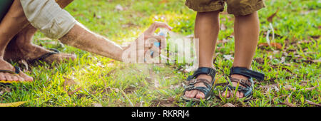 Papà e figlio utilizzare spray di zanzara.la spruzzatura di repellente per insetti sulla pelle outdoor, formato lungo Foto Stock