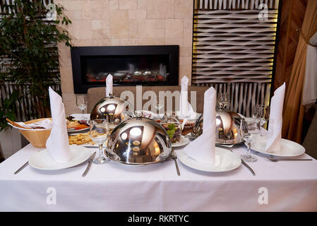 Servita la cena table.piatto caldo sulla cupola il vassoio sulla tavola server. Foto Stock