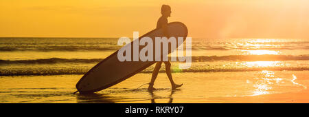 Vacanza Silhouette di un surfista portando la sua tavola da surf Home al tramonto con copia spazio banner, formato lungo Foto Stock