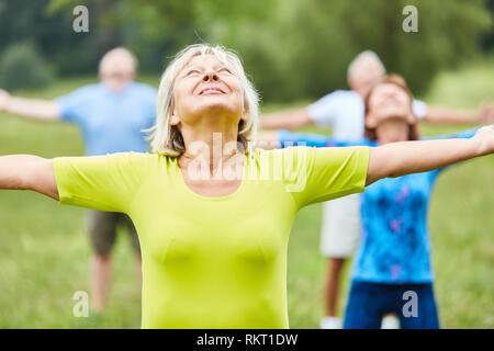 Gruppo attivo di anziani facendo ginnastica classe insieme nel parco Foto Stock