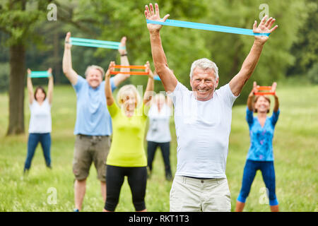 Seniors esercizio fitness con fascia elastica in fisioterapia riabilitativa in corso Foto Stock