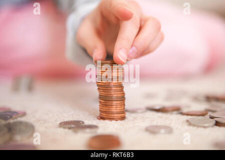 Bambino monete di impilamento di pocket money Foto Stock