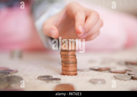 Bambino monete di impilamento di pocket money Foto Stock