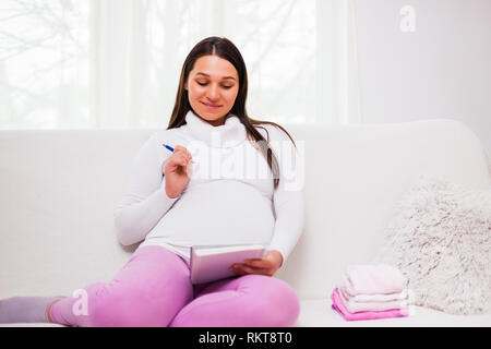 Donna incinta iscritto alla lista delle attività. Foto Stock