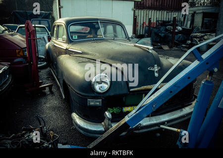 Americana Classica berlina Chrysler auto Highlands scozzesi, seduta abbandonato sul piazzale del garage Foto Stock