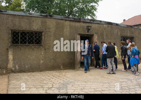 Oswiecim, Polonia - 11 luglio 2018. I visitatori del campo di concentramento di Auschwitz in linea fino a passare all'interno di un ex camera del gas Foto Stock