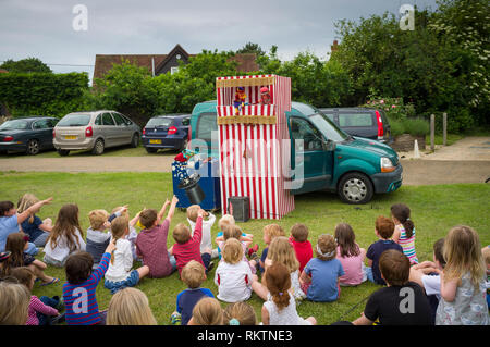 I bambini godono la tradizionale Punch & Judy Show a Great Milton Fete, Oxfordshire. Foto Stock