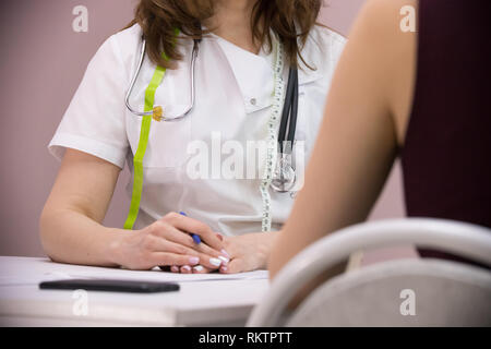 La cosmetologia clinica di bellezza. Il medico e il paziente a prendere appunti presso l'ufficio del medico Foto Stock