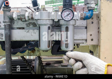 Il lavoratore controllare il filtro dell'aria regulator‎ sistema pneumatico factory Foto Stock