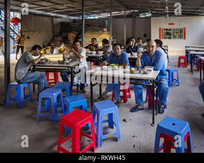 Sihanoukville, Preah Sihanouk, Cambogia. 12 Feb, 2019. Costruzione cinese Lavoratori mangiano la cena in una delle sale da pranzo in un cinese labour camp in Sihanoukville. Ci sono circa 50 casinò cinese e resort hotel aperto o in costruzione in Sihanoukville. I CASINÒ sono cambiando la città, una volta che una sonnolenta porta sul sudest asiatico del ''backpacker trail'' in una fiorente città. Il cambiamento è in arrivo con un costo però. Molti residenti cambogiano di Sihanoukville hanno perso le loro case per fare la strada per il casinò e i lavori sono in corso per lavoratori cinesi, portò alla costruzione di casinò e Foto Stock