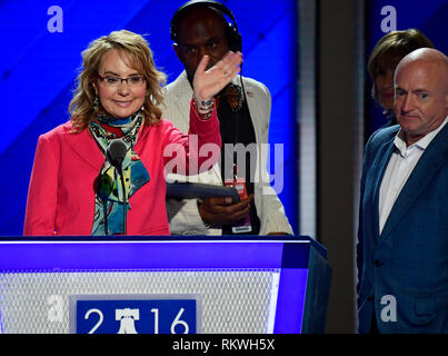 Ex rappresentante degli Stati Uniti Gabby Giffords (Democratico di Arizona) onde come lei che ripete il suo commento prima della sessione di apertura del 2016 Convenzione Nazionale Democratica presso la Wells Fargo Center di Philadelphia, in Pennsylvania, il Lunedì 25 Luglio, 2016. Il marito ex astronauta Mark Kelly guarda su da destra. Credito: Ron Sachs/CNP (restrizione: NO New York o New Jersey o giornali quotidiani nel raggio di 75 miglia da New York City) | utilizzo in tutto il mondo Foto Stock