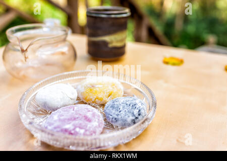 Teiera e mochi torta di riso dolce giapponese wagashi daifuku colorati sul colore tabella con quattro pezzi closeup Foto Stock