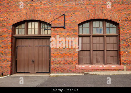 Una grande porta e finestra sul lato di un vecchio rosso edificio in mattoni Foto Stock