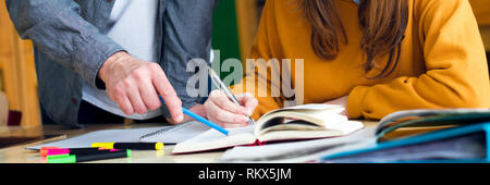 Giovane insegnante aiutando il suo studente in chimica classe. Istruzione, tutoring e incoraggiamento del concetto. Foto Stock