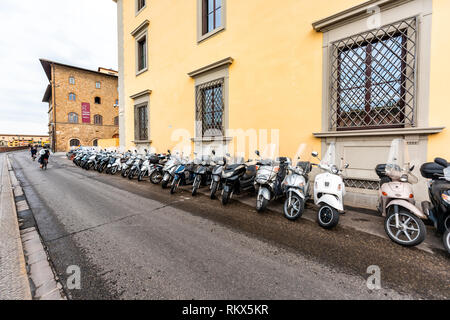 Firenze, Italia - 31 agosto 2018: Firenze giallo arancio edifici dal fiume Arno durante l estate Mattina nuvoloso in Toscana con moto parcheggiate Foto Stock