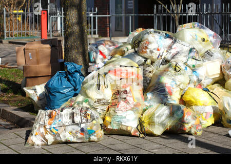 Giallo sacchi per rifiuti in plastica, giacente sul cordolo, Brema, Germania ho Gelbe Säcke für Plastikmüll, auf dem Bordstein liegend, Brema, Deutschland I Foto Stock