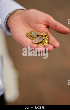 Uomo con monete nel palmo della mano Foto Stock