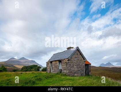 Un abbandonato crofters cottage, ora utilizzato come rifugio per gli ovini, con montagne Cul Mor e Suilven in background, Elphin, Sutherland, Scozia Foto Stock