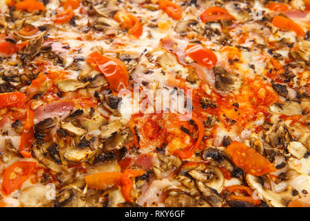 Sfondo dalla deliziosa classic pizza italiana Carbonara con prosciutto, pomodori, funghi e formaggio Foto Stock