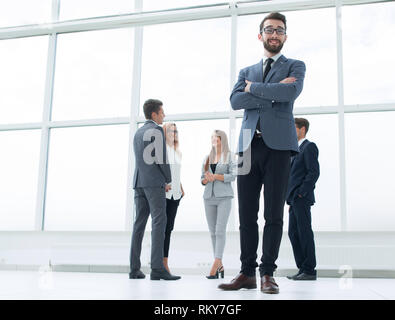 Vista dal basso.imprenditore di successo in piedi in un luminoso ufficio. Foto Stock