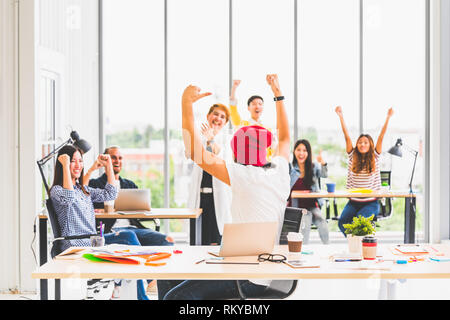 Multietnica variegato gruppo di team creativo o business collaboratore celebrare insieme in un ufficio moderno. Il successo del lavoro di squadra o azienda startup concept Foto Stock