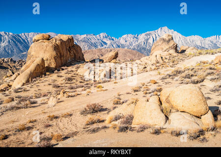 Strada sterrata conduce attraverso le formazioni rocciose in Alabama Hills, Lone Pine, California, Stati Uniti d'America. Foto Stock