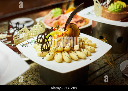 Righe di gustosi dessert cercando in regime di bello. Caramelle sul tavolo per banchetti - foto scattata durante l'evento di catering Foto Stock
