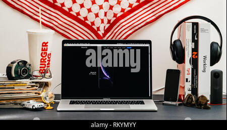 LONDON, Regno Unito - Sep 13, 2018: Creative stanza tavolo con il browser Safari su laptop MacBook Pro vetrina per i computer Apple più recenti sito web iPhone Xs smartphone con Foto Stock