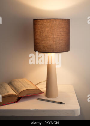 Lampada di notte e prenota sul bianco scrivania o comodino. Apprendimento o concetto di studio Foto Stock