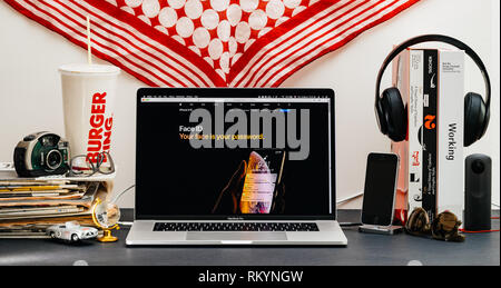 LONDON, Regno Unito - Sep 13, 2018: Creative stanza tavolo con il browser Safari su laptop MacBook Pro vetrina per i computer Apple più recenti sito web iPhone Xs smartphone con FaceID Foto Stock