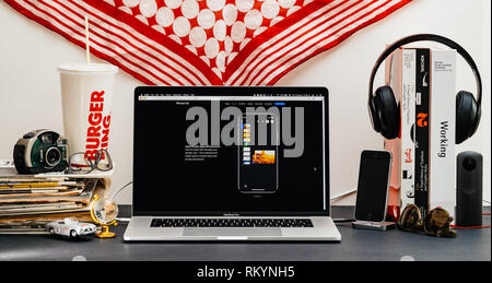 LONDON, Regno Unito - Sep 13, 2018: Creative stanza tavolo con il browser Safari su laptop MacBook Pro vetrina per i computer Apple più recenti sito web iPhone Xs smartphone con faceid log-in per conto Foto Stock