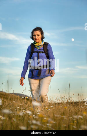 Donna matura con zaino escursionismo sulla punta orientale Trail, trota fiume, Terranova. Foto Stock