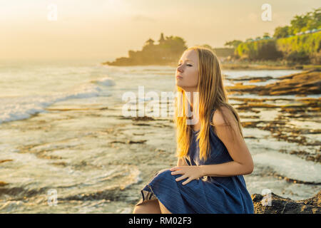 Giovane donna tourist sullo sfondo di Tanah Lot - Tempio nell'oceano. Bali, Indonesia Foto Stock