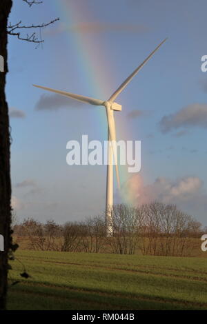 Turbina eolica con un arcobaleno dietro di essa Foto Stock