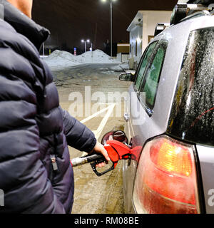 Uomo di pompaggio del carburante benzina in auto alla stazione di gas di trasporto e il concetto di proprietà Foto Stock