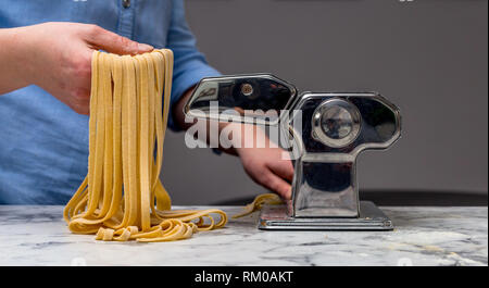 Fresco di tagliatelle fatte da una macchina per la pasta Foto Stock