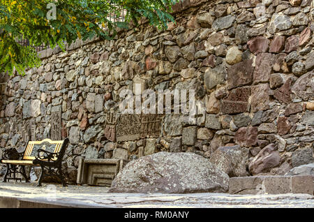 Una parete assemblato da medievale conservata in frammenti di croci in pietra, ornamenti intagliati e la facciata dettagli sul territorio del monastero Gegard di un Foto Stock