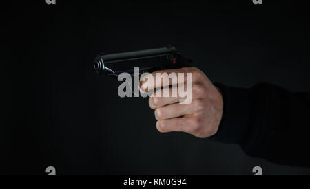 Uomo con una pistola in mano Foto Stock