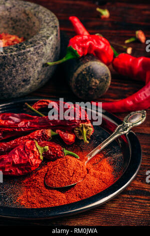 Cucchiaio di terra peperoncino con frutta secca sulla piastra di metallo Foto Stock