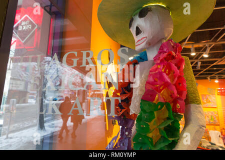 Seattle, Washington: una figura a colori di La Calavera Catrina a Milagros arte popolare messicana si affaccia su 1° Avenue come una forte tempesta di neve coperta Foto Stock