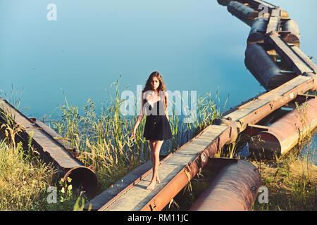 La donna a piedi su metallo pontoon ponte sul fiume Foto Stock