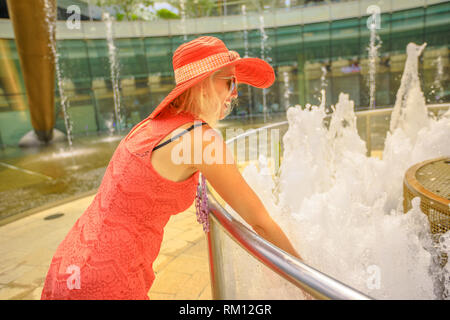 Felice tourist godendo al più grande fontana nel mondo. Fontana della Ricchezza a Suntec Tower la più grande fontana in Singapore. Lo stile di vita della donna con Foto Stock