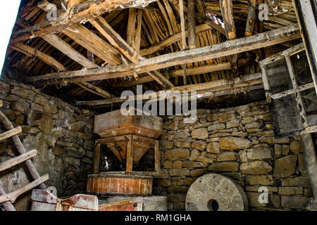 Interno del vecchio mulino ad acqua, grande pietra circolare, scale a pioli e altro personale che sono coperti di polvere e la ragnatela. Rosomac, Slavinjsko Foto Stock