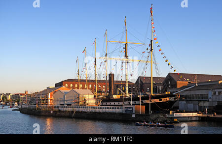 I rematori passando la SS Gran Bretagna, Bristol Docks, Sud Ovest Inghilterra al tramonto di sera. Foto Stock