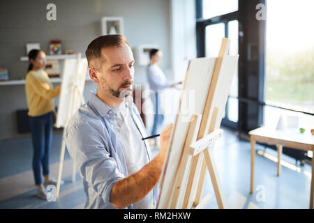 L'uomo pittura in studio Foto Stock