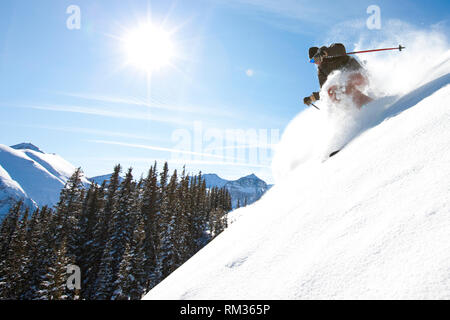 Sciatore jump passando attraverso la fresca neve profonda Foto Stock